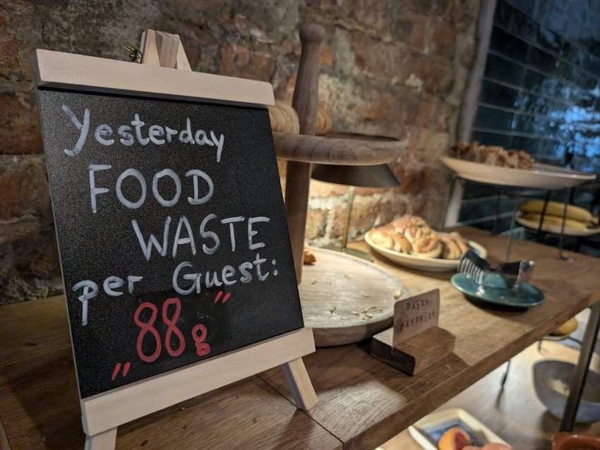 A reminder at the breakfast buffet to watch what you eat. The sign lists yesterday's food waste per guest, which, at 88 grams, is better than average